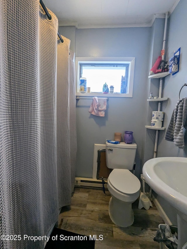 26-28 Glinko St, Scranton, PA 18504 - full bathroom featuring wood finished floors, a baseboard heating unit, toilet, ornamental molding, and a shower with shower curtain
