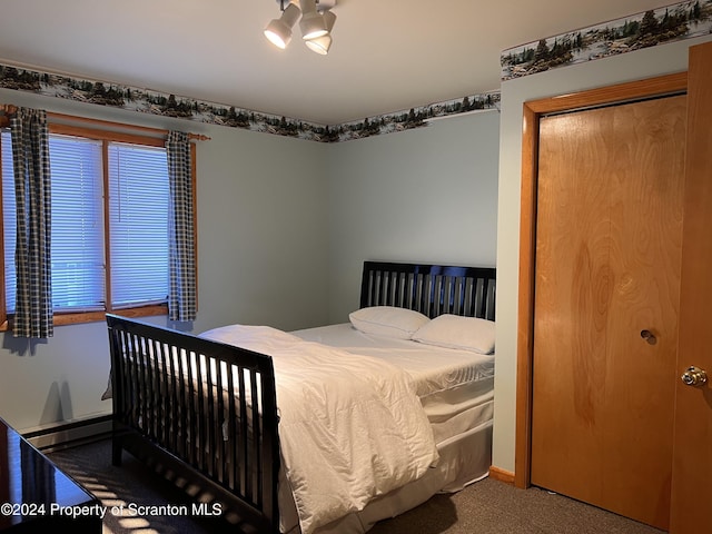 carpeted bedroom with baseboard heating and a closet