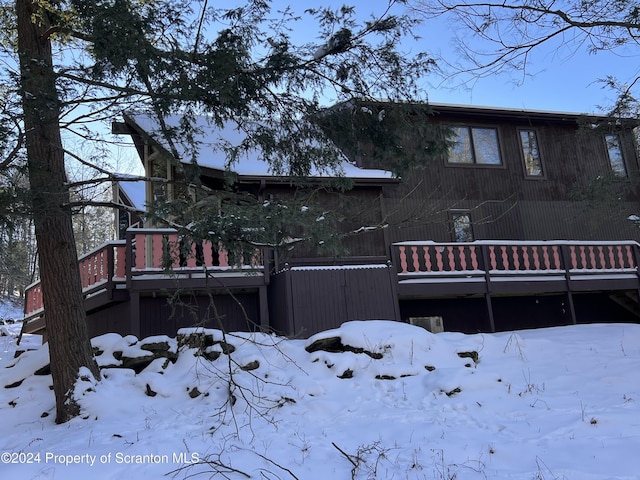 view of snow covered back of property