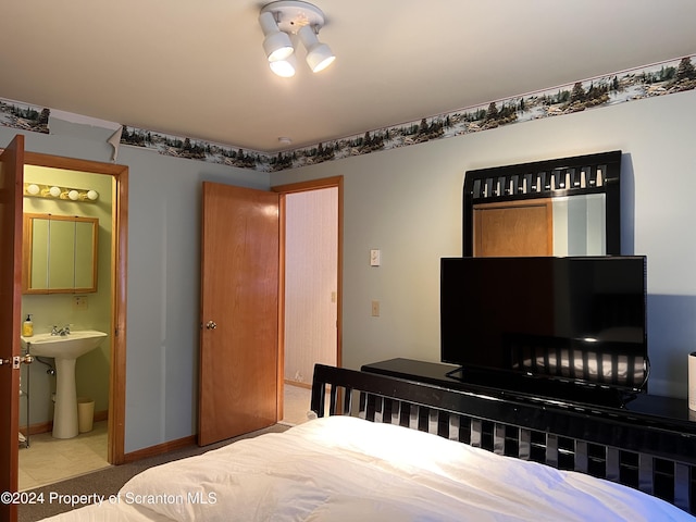 bedroom featuring ensuite bath and sink