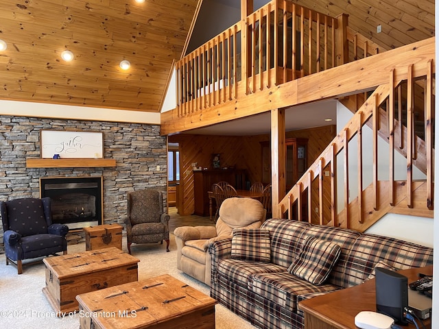 living room featuring wood walls, wooden ceiling, high vaulted ceiling, a fireplace, and carpet floors