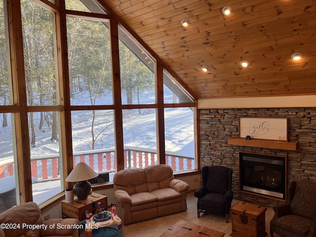 unfurnished living room featuring vaulted ceiling, light colored carpet, a stone fireplace, and wood ceiling