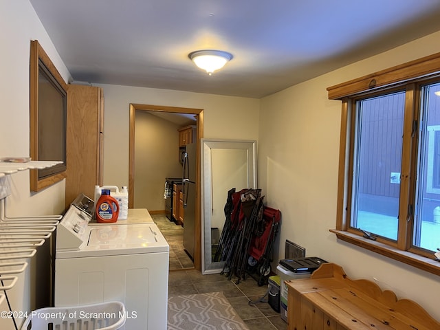 laundry room with dark tile patterned floors and independent washer and dryer