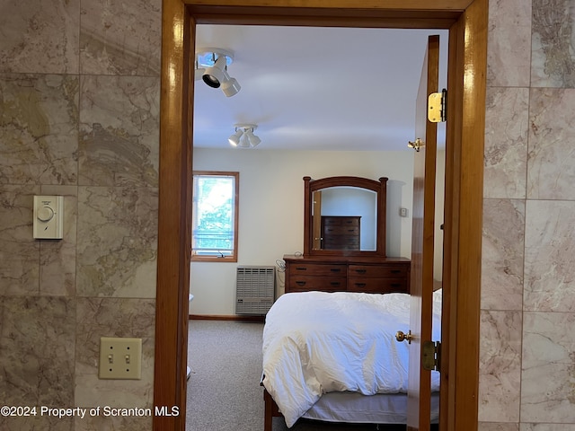 unfurnished bedroom featuring carpet and tile walls