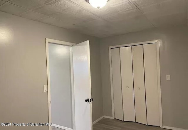 unfurnished bedroom featuring hardwood / wood-style floors and a closet