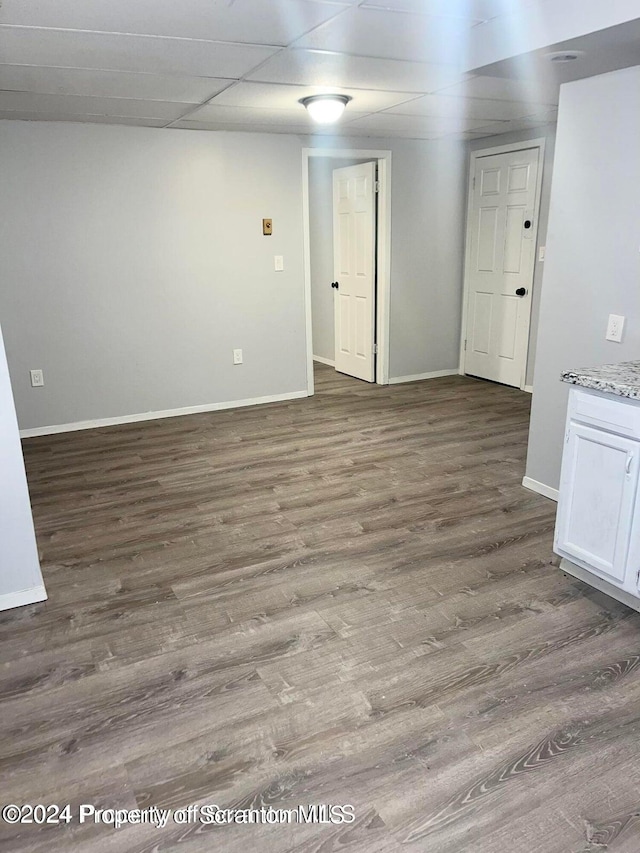 unfurnished room with dark hardwood / wood-style floors and a paneled ceiling