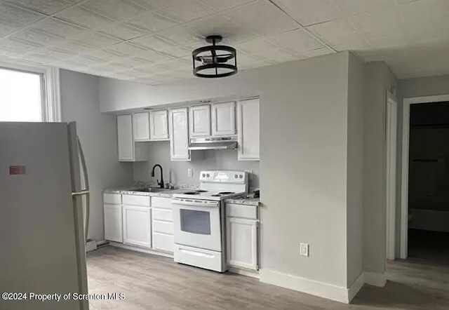 kitchen with white cabinets, sink, white electric range, and stainless steel fridge