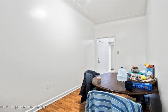 dining space with light wood-type flooring and baseboards