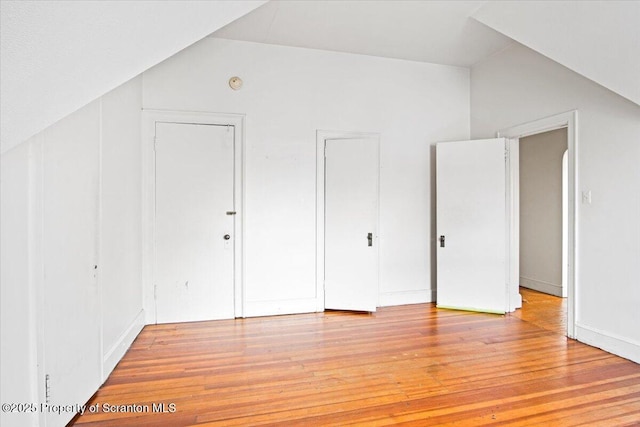 additional living space with light wood finished floors and vaulted ceiling