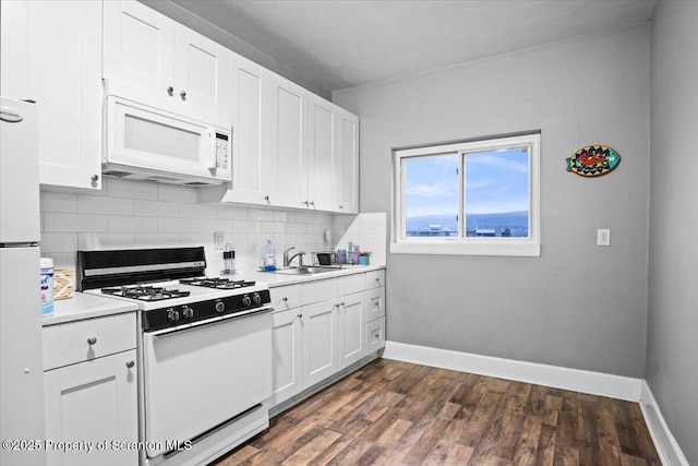 kitchen featuring white appliances, light countertops, a sink, and backsplash