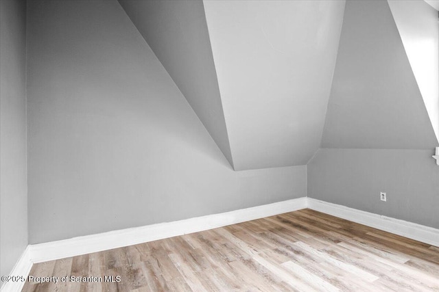 bonus room with lofted ceiling, baseboards, and wood finished floors