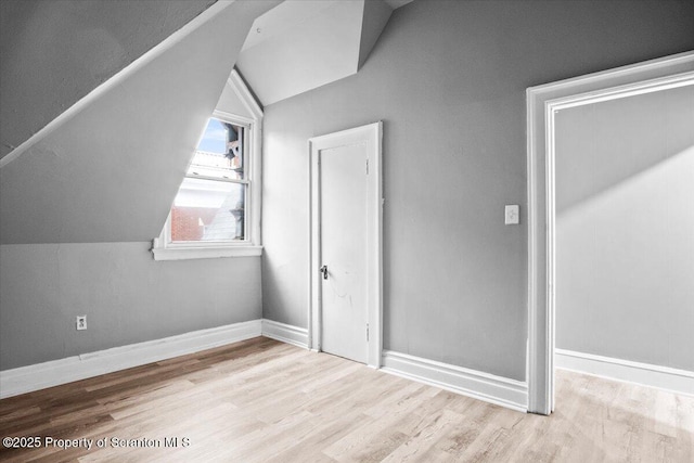 bonus room with lofted ceiling, baseboards, and wood finished floors