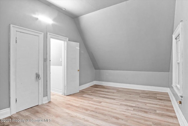 bonus room featuring lofted ceiling, baseboards, and light wood-style floors