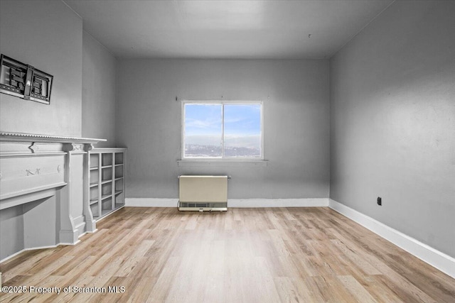 unfurnished living room featuring baseboards and wood finished floors