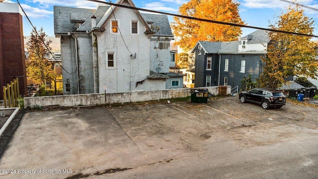 view of side of property featuring uncovered parking and fence