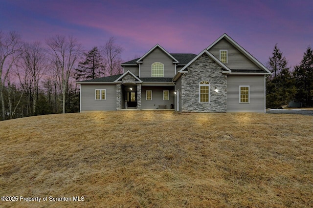 craftsman house with stone siding and a front yard