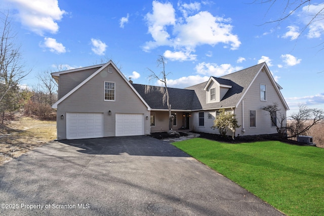 view of front of home with aphalt driveway, a front yard, and roof with shingles