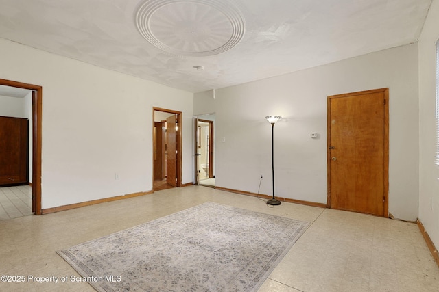empty room featuring tile patterned floors and baseboards
