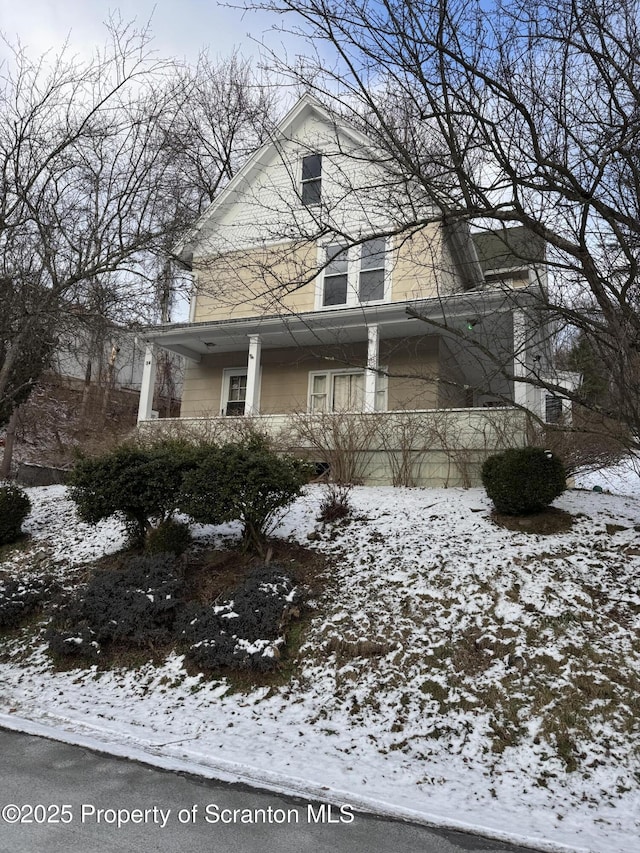 view of snowy exterior featuring covered porch