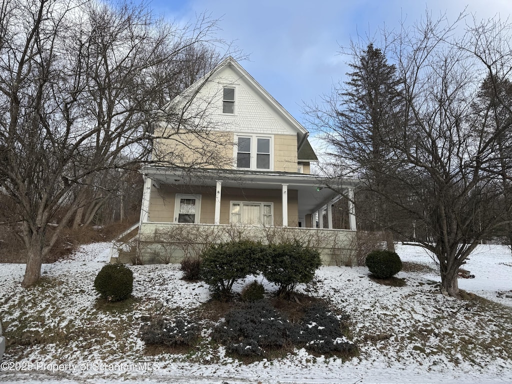 view of snowy exterior featuring a porch