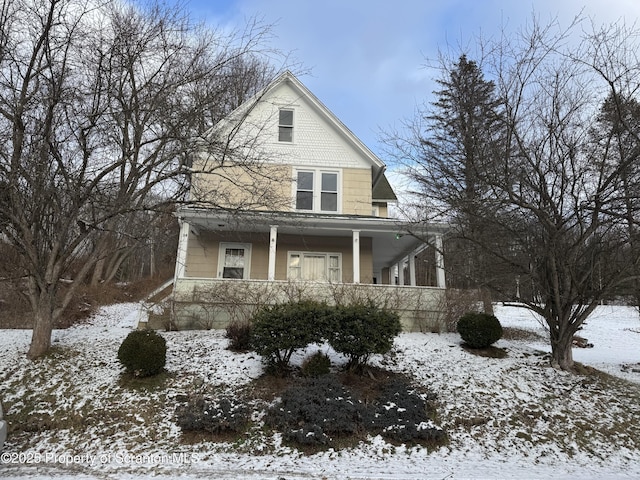 view of snowy exterior featuring a porch