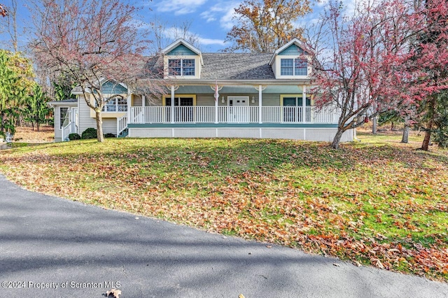 new england style home with covered porch and a front lawn