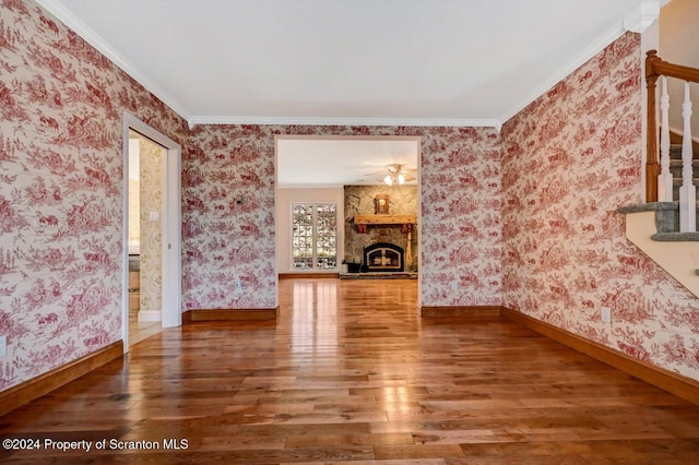 unfurnished living room featuring a fireplace, wood-type flooring, and crown molding