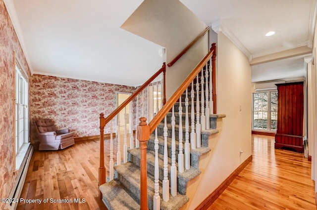 staircase featuring a baseboard radiator, hardwood / wood-style flooring, and crown molding