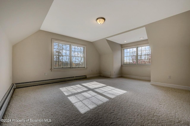 additional living space with light colored carpet, vaulted ceiling, and a baseboard heating unit