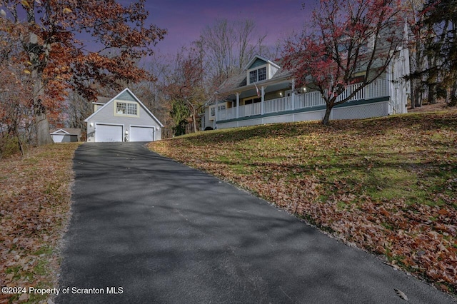 property exterior at dusk with an outbuilding, a garage, and covered porch