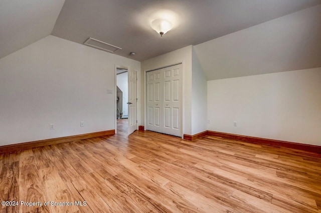 additional living space featuring vaulted ceiling and light hardwood / wood-style flooring