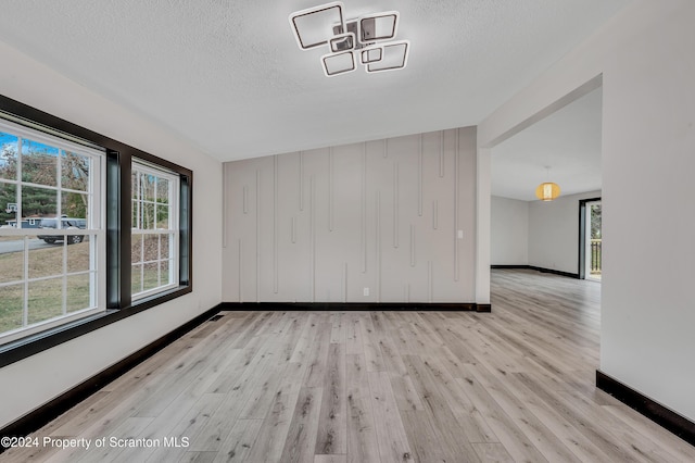 interior space with a textured ceiling, light wood-type flooring, and plenty of natural light