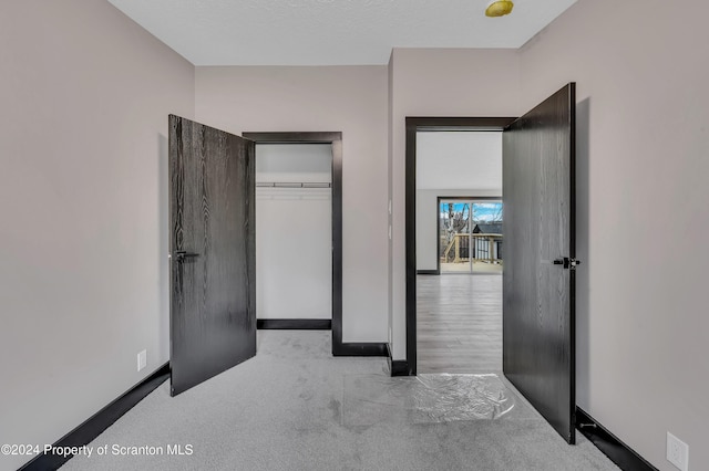 unfurnished bedroom with light carpet and a closet