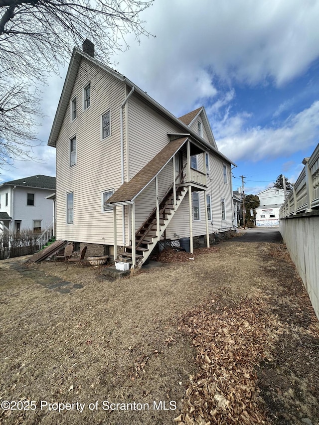 rear view of house with fence and a chimney