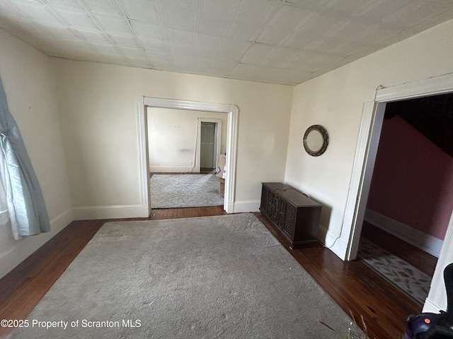 unfurnished room featuring dark wood-type flooring and baseboards