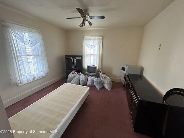 bedroom with ceiling fan, dark carpet, and baseboards