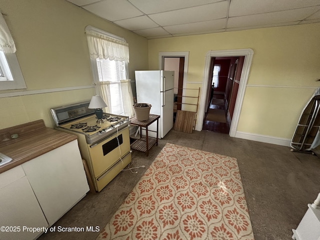 kitchen with white appliances and a drop ceiling