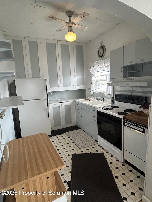 kitchen with ceiling fan, under cabinet range hood, white appliances, white cabinetry, and light countertops