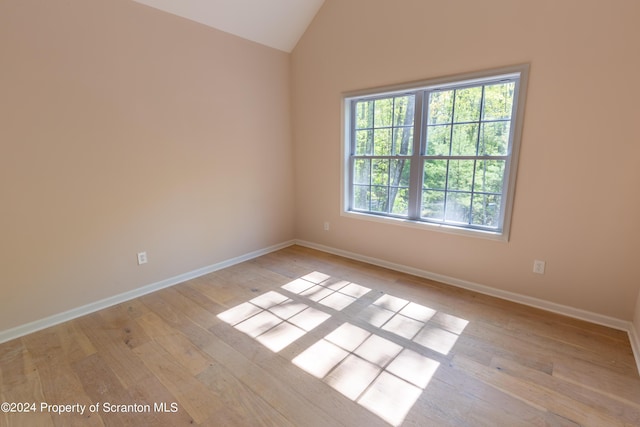 empty room featuring light wood-type flooring and lofted ceiling