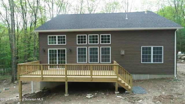 rear view of property featuring a wooden deck