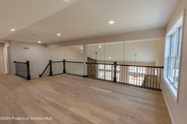 spare room featuring light hardwood / wood-style flooring and vaulted ceiling