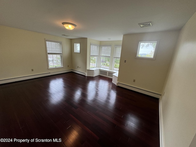 empty room featuring a baseboard radiator and dark wood-type flooring