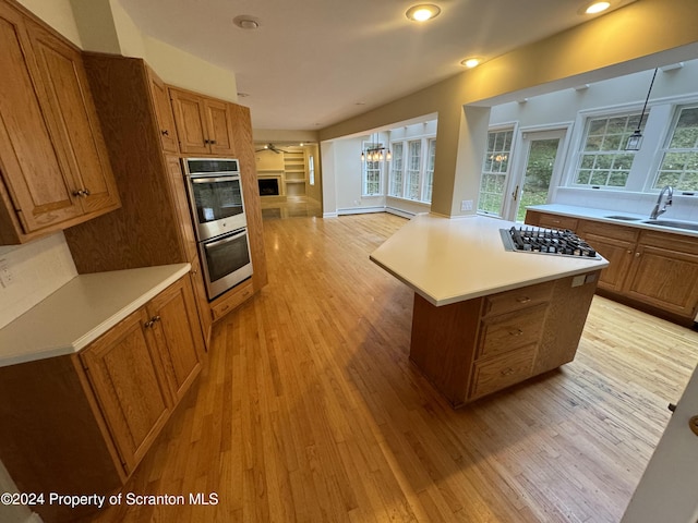 kitchen featuring a center island, an inviting chandelier, sink, light hardwood / wood-style flooring, and stainless steel appliances