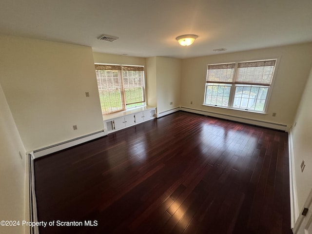 spare room featuring hardwood / wood-style floors and a baseboard heating unit