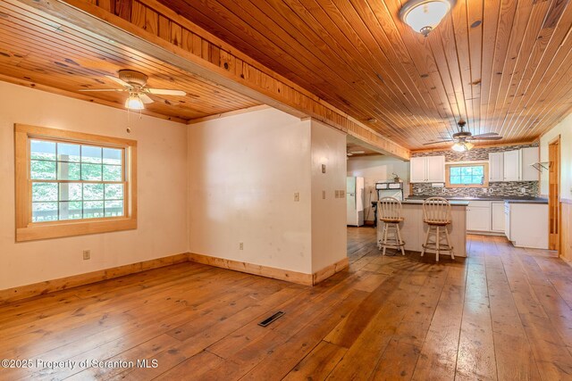 2269 Creek Rd, New Milford, PA 18834 - kitchen with a ceiling fan, wooden ceiling, white cabinets, light wood-style flooring, and a kitchen bar