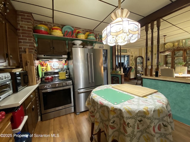 906 Cedar Ave, Scranton, PA 18505 - kitchen with appliances with stainless steel finishes, under cabinet range hood, a chandelier, light countertops, and a paneled ceiling