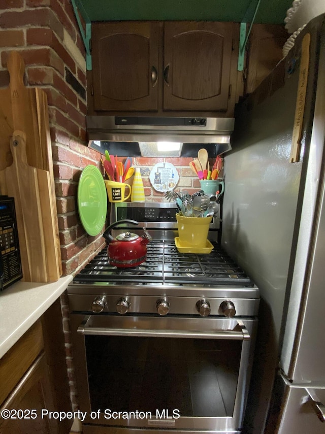 906 Cedar Ave, Scranton, PA 18505 - kitchen view of stainless steel range with gas stovetop, extractor fan, light countertops, and decorative backsplash