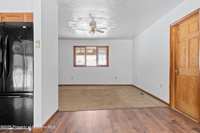 empty room with baseboards, dark wood finished floors, and a textured ceiling