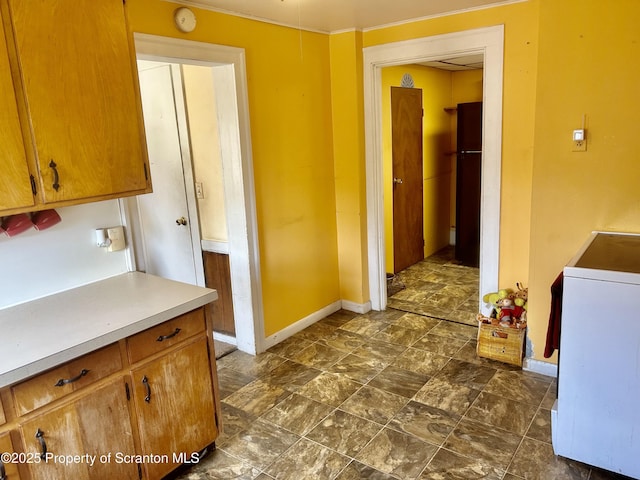 laundry area with baseboards and dark stone finish flooring