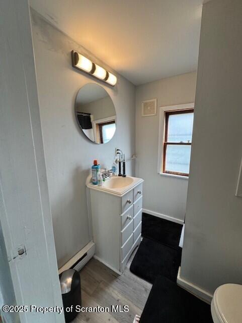 1449 Dickens St, Scranton, PA 18504 - bathroom with vanity, toilet, baseboard heating, wood finished floors, and baseboards